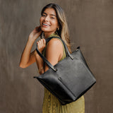 Pebbled--black Zipper | Model holding large zipper leather tote bag with sturdy bridle handles and front pocket