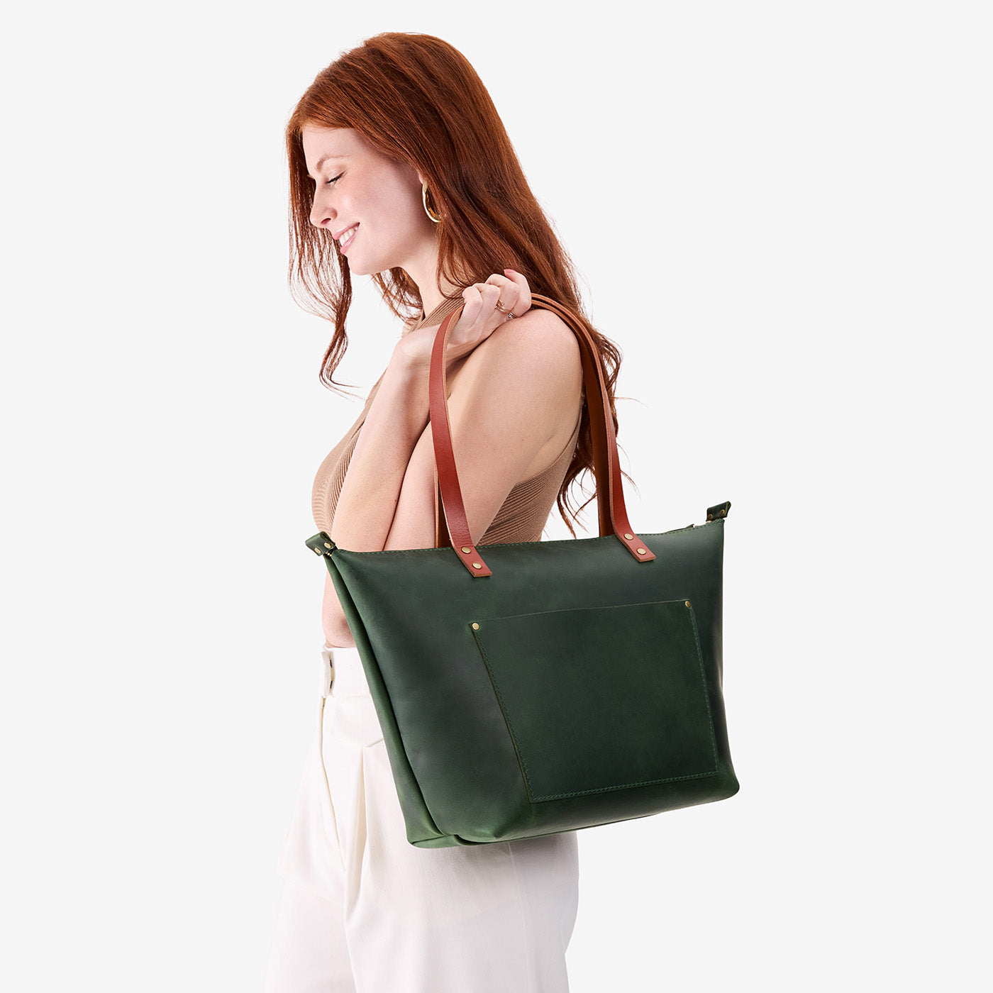 Evergreen*Zipper | Model holding large leather tote bag with sturdy bridle handles and front pocket