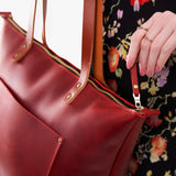Phoenix Zipper | Model holding large leather tote bag with sturdy bridle handles and front pocket