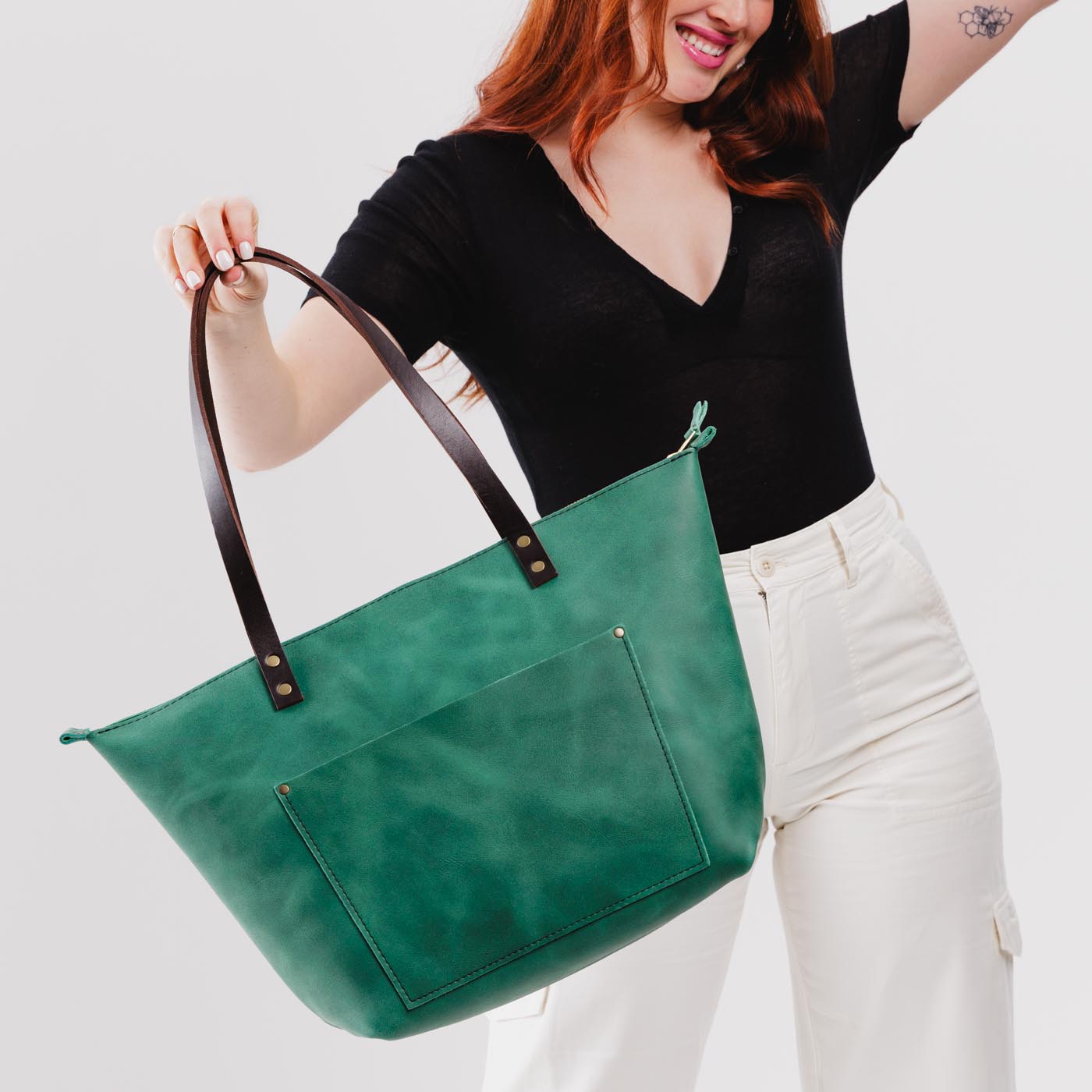 Surf*Zipper | Model holding large leather tote bag with sturdy bridle handles and front pocket