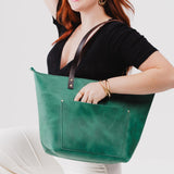 Surf Zipper | Model holding large zipper leather tote bag with sturdy bridle handles and front pocket