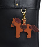 Clyde | A horse-shaped keychain hanging on a pebbled black bag