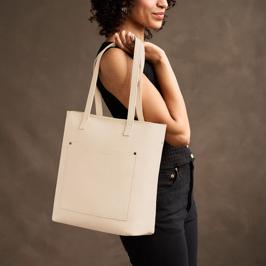 Pebbled Bone*Zipper | Model holding medium Tote with dual shoulder straps and crossbody strap