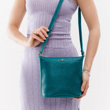 Aquarius | Model holding rectangular side bag with curved front pocket and metal tree shaped badge