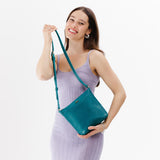 Aquarius | Model wearing rectangular side bag with curved front pocket and metal tree shaped badge