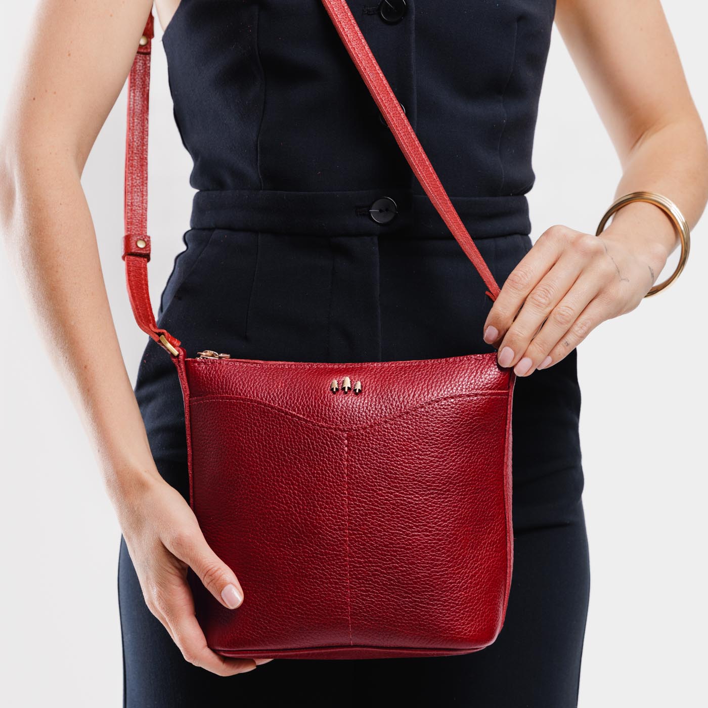 Chili Red | Model wearing rectangular side bag with curved front pocket and metal tree shaped badge