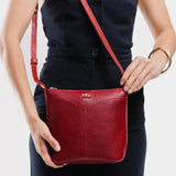 Chili Red | Model wearing rectangular side bag with curved front pocket and metal tree shaped badge