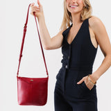 Chili Red | Model wearing rectangular side bag with curved front pocket and metal tree shaped badge