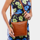 Sienna | Model holding rectangular side bag with curved front pocket and metal tree shaped badge