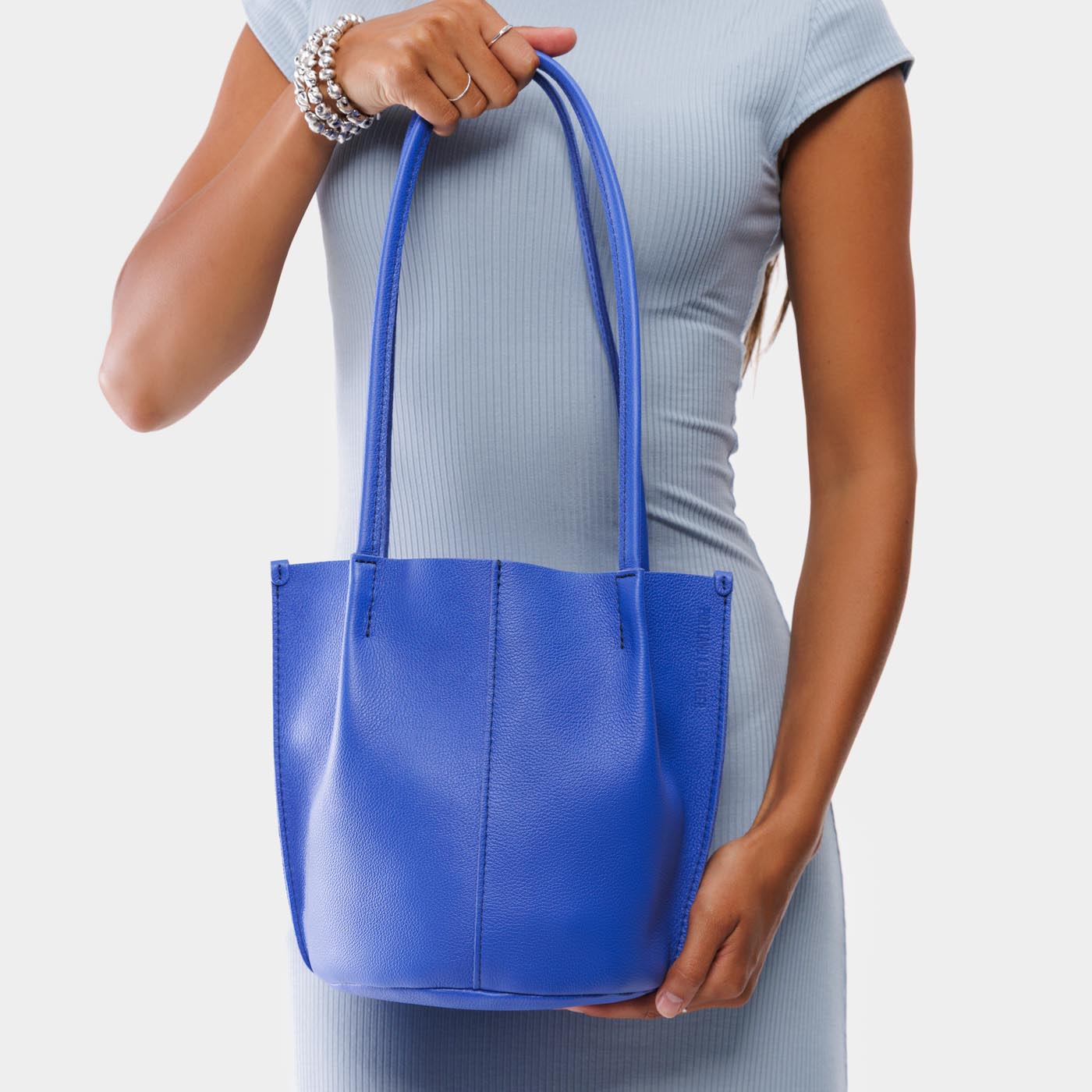 Astro Blue*Classic | Model holding petite bucket shaped tote bag with matching leather handles