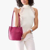 Cosmo Classic | Model wearing matching white sleeveless shirt and pants holding petite bucket shaped tote bag with matching leather handles