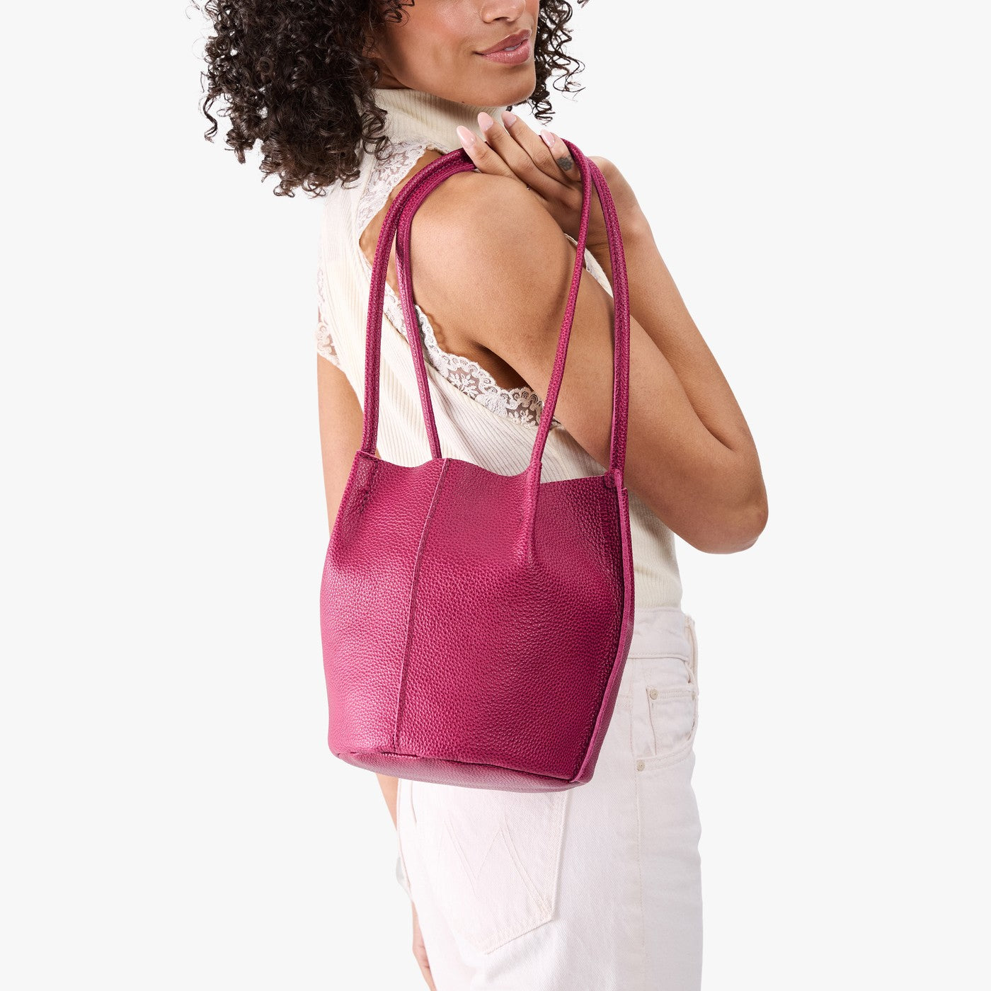 Cosmo*Classic | Model wearing matching white sleeveless shirt and pants holding petite bucket shaped tote bag with matching leather handles