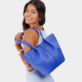Astro Blue Large | Model holding wide bucket shaped tote bag with matching leather handles