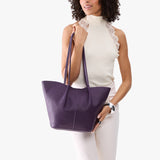 Empire Large | Model wearing white sleeveless shirt and matching pants holding wide bucket shaped tote bag with matching leather handles