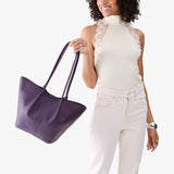 Empire Large | Model wearing white sleeveless shirt and matching pants holding wide bucket shaped tote bag with matching leather handles