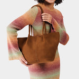 Jackson Large | Model holding a brown leather tote bag 
