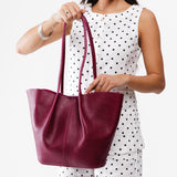 Orchid Large | Model holding wide bucket shaped tote bag with matching leather handles