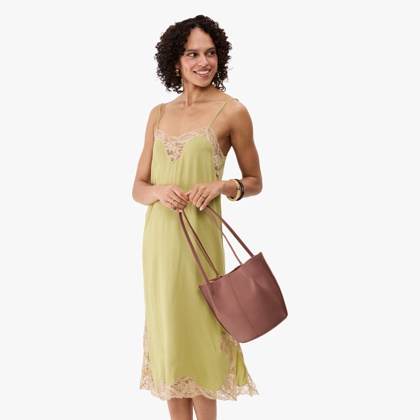 Sunkissed*Classic | Model wearing sleeveless light green dress holding petite bucket shaped tote bag with matching leather handles