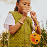 All Variants | Child in nature holding a Duckie Pouch in the color Sunshine