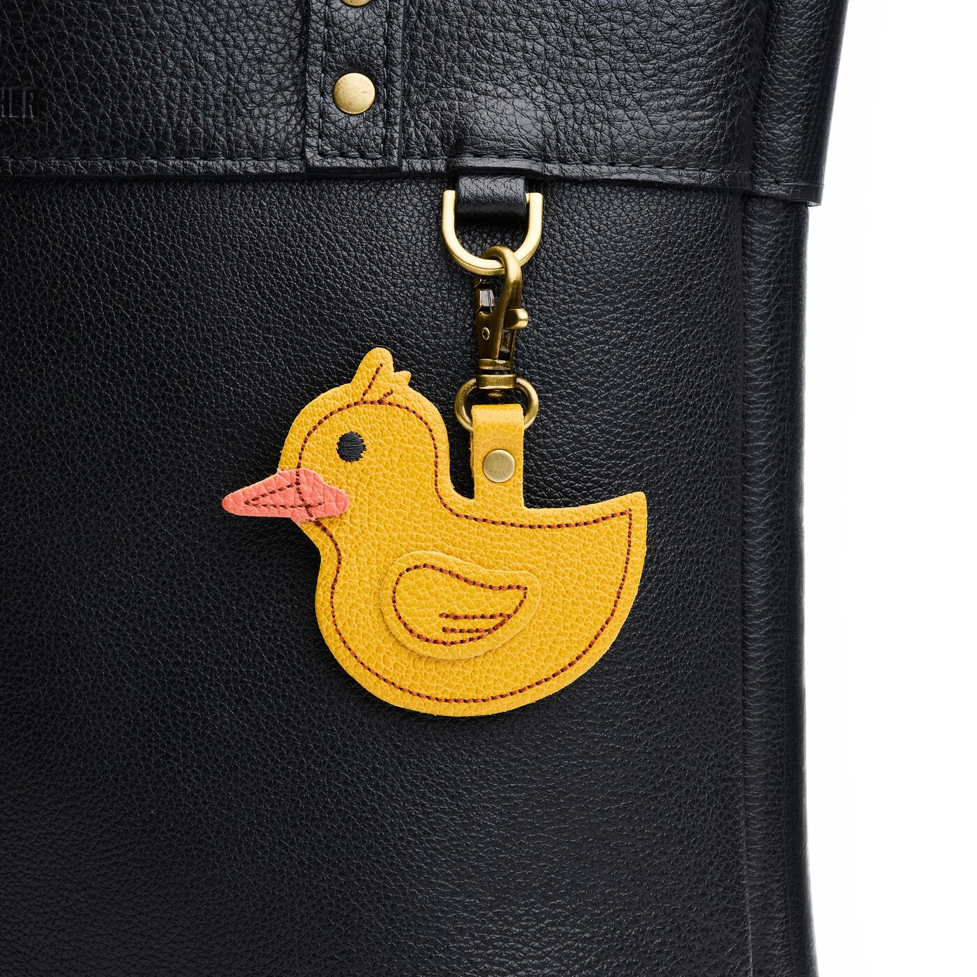 Duke | A duck-shaped keychain hanging on a pebbled black bag