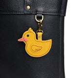 Duke | A duck-shaped keychain hanging on a pebbled black bag