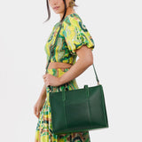 Aruba East/West | Model wearing structured wide tote bag with overlapping panels and crossbody strap