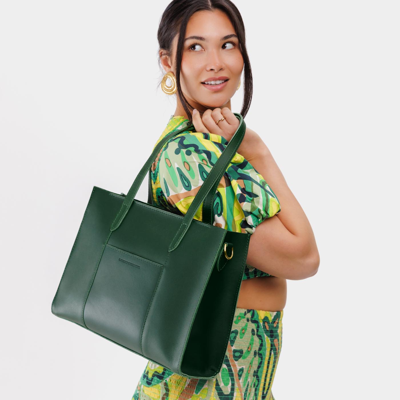 Aruba*East/West | Model wearing structured wide tote bag with overlapping panels and crossbody strap