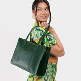 Aruba East/West | Model wearing structured wide tote bag with overlapping panels and crossbody strap