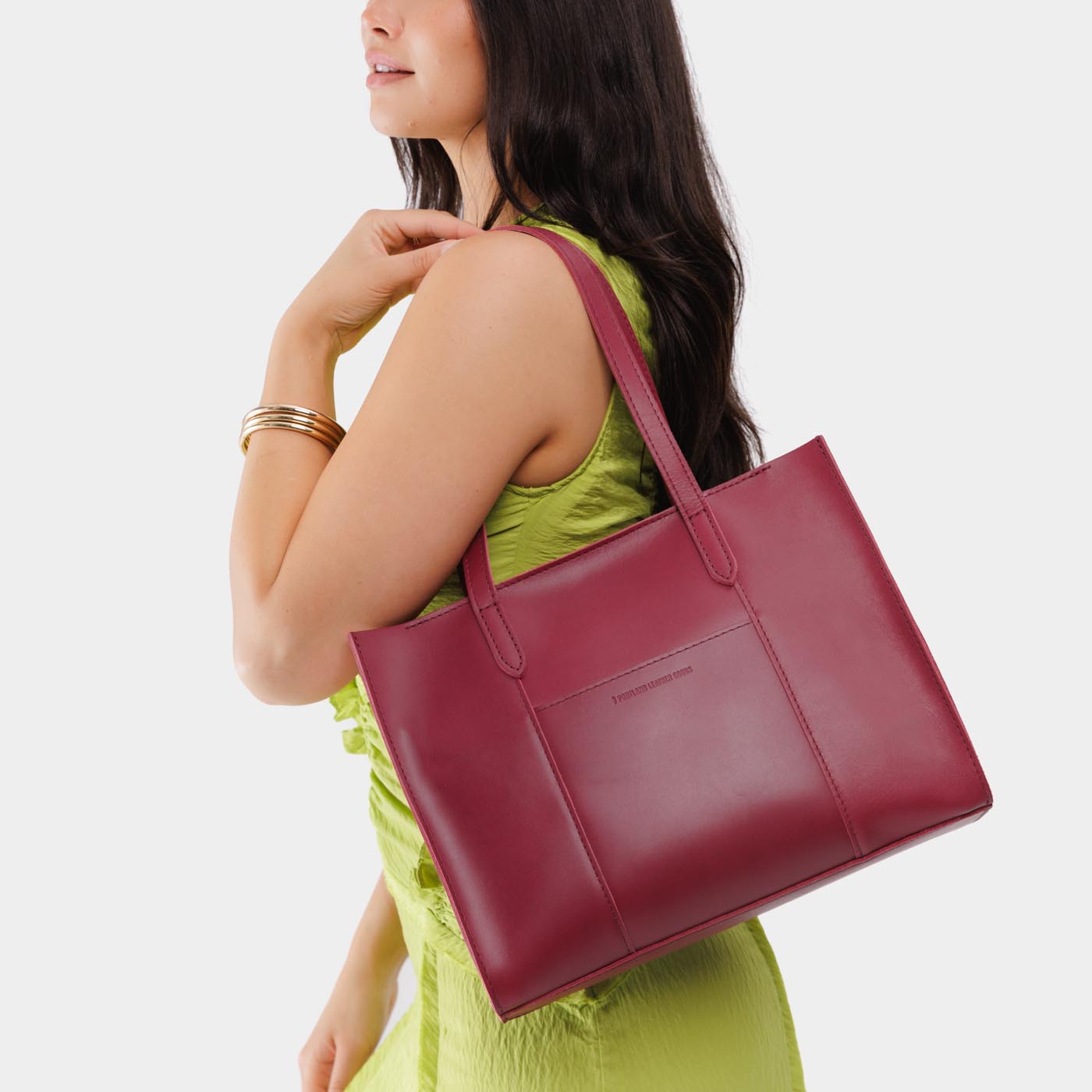 Berry Good*East/West | Model wearing structured wide tote bag with overlapping panels and crossbody strap