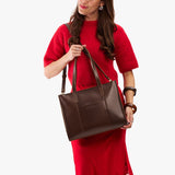 Chocolate Brown East/West | Model wearing structured wide tote bag with overlapping panels and crossbody strap