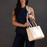 Moonflower East/West | Model wearing structured wide tote bag with overlapping panels and crossbody strap