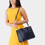 Night Owl East/West | Model wearing structured wide tote bag with overlapping panels and crossbody strap