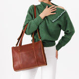 Nutmeg East/West | Model wearing structured wide tote bag with overlapping panels and crossbody strap