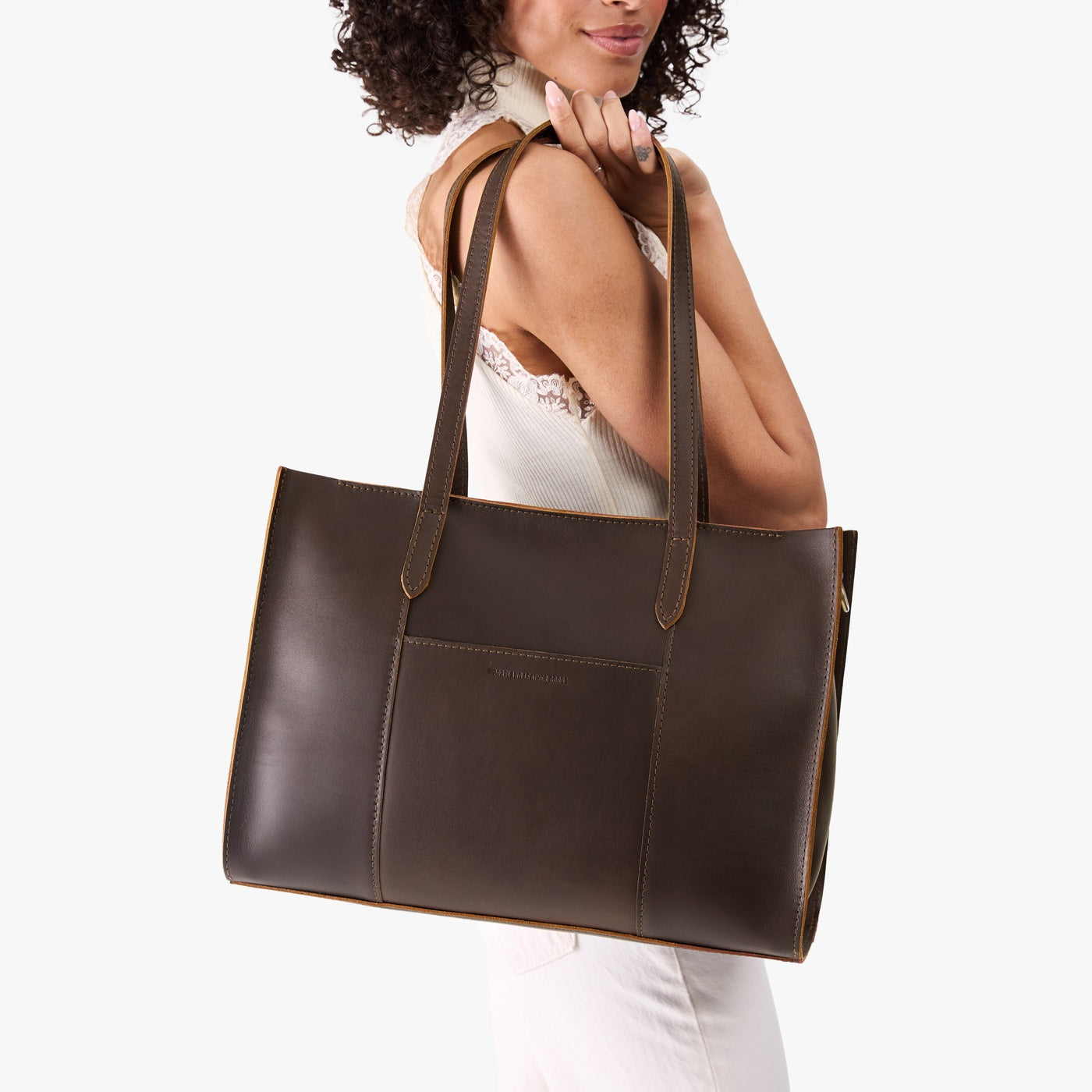 Grizzly*Oversized East/West | Model holding structured wide tote bag with overlapping panels and crossbody strap