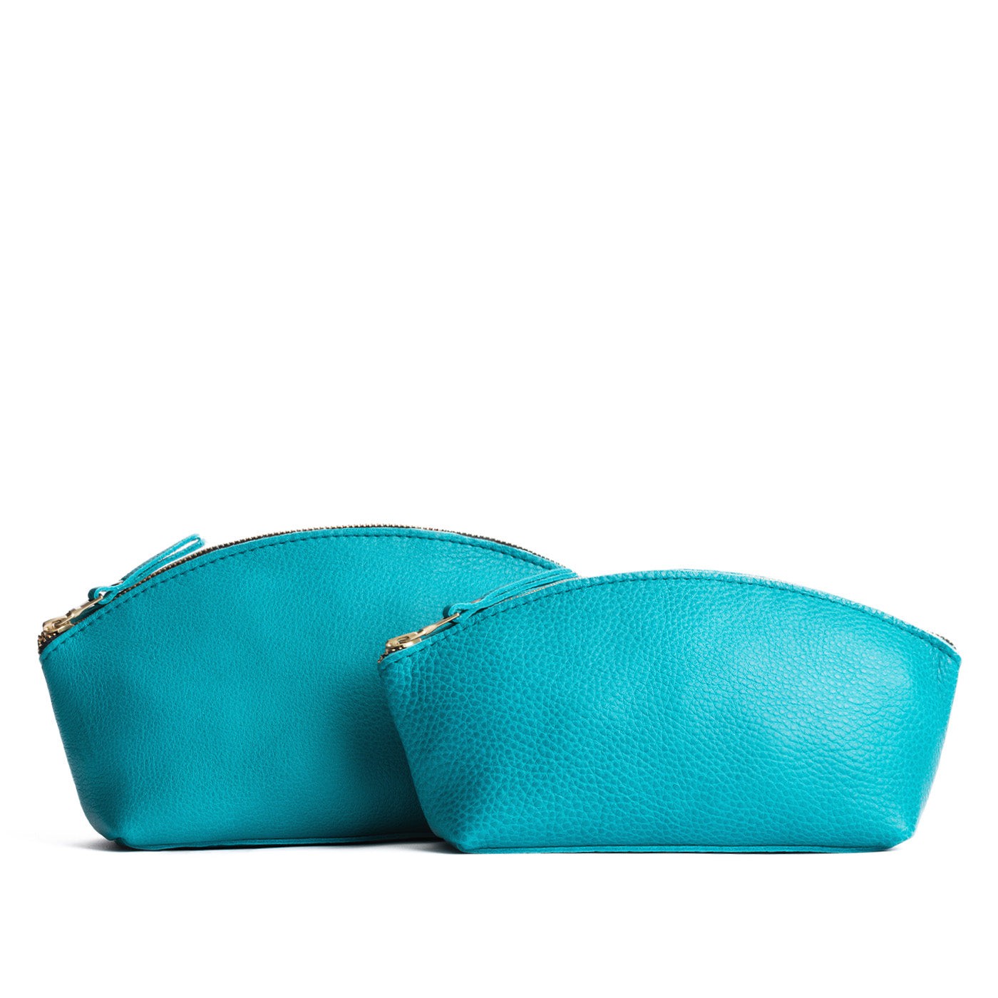 Baja | Size comparison shot of two spacious leather makeup bags with curved seams and top zipper