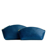 Caspian | Size comparison shot of two spacious leather makeup bags with curved seams and top zipper