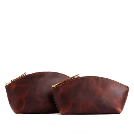 Lava | Size comparison shot of two spacious leather makeup bags with curved seams and top zipper