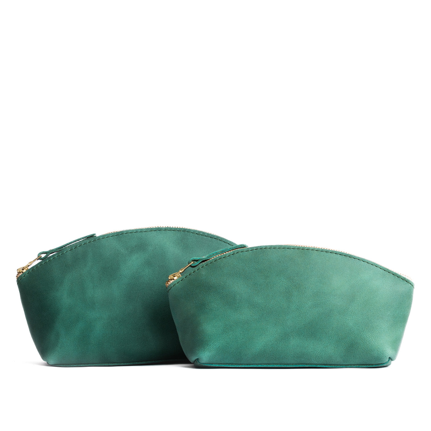 Surf | Size comparison shot of two spacious leather makeup bags with curved seams and top zipper