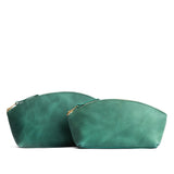 Surf | Size comparison shot of two spacious leather makeup bags with curved seams and top zipper