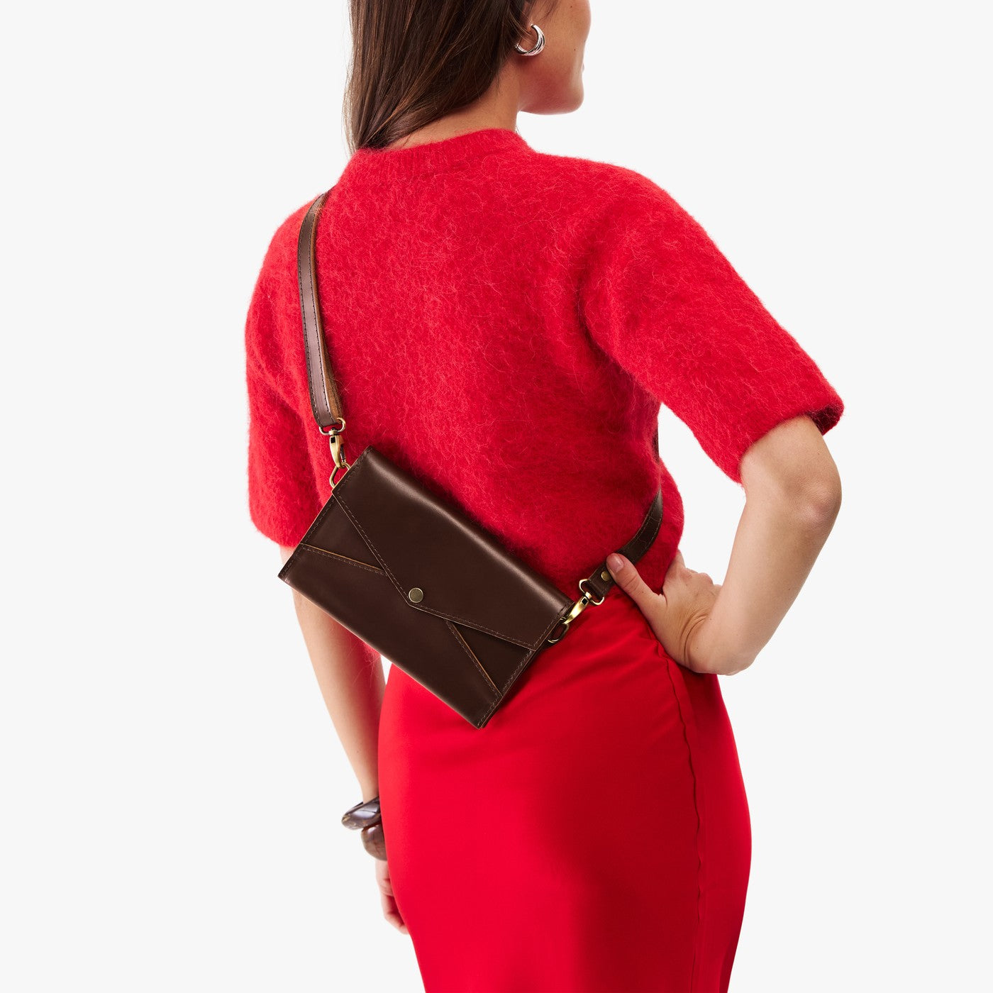 Chocolate Brown | Woman in a red dress wearing a brown Envelope Crossbody against a white background