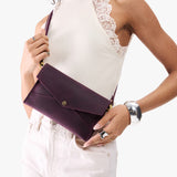 Larkspur | Model holding envelope shaped clutch wallet with crossbody strap
