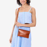 Madrone | Model holding envelope shaped clutch wallet with crossbody strap
