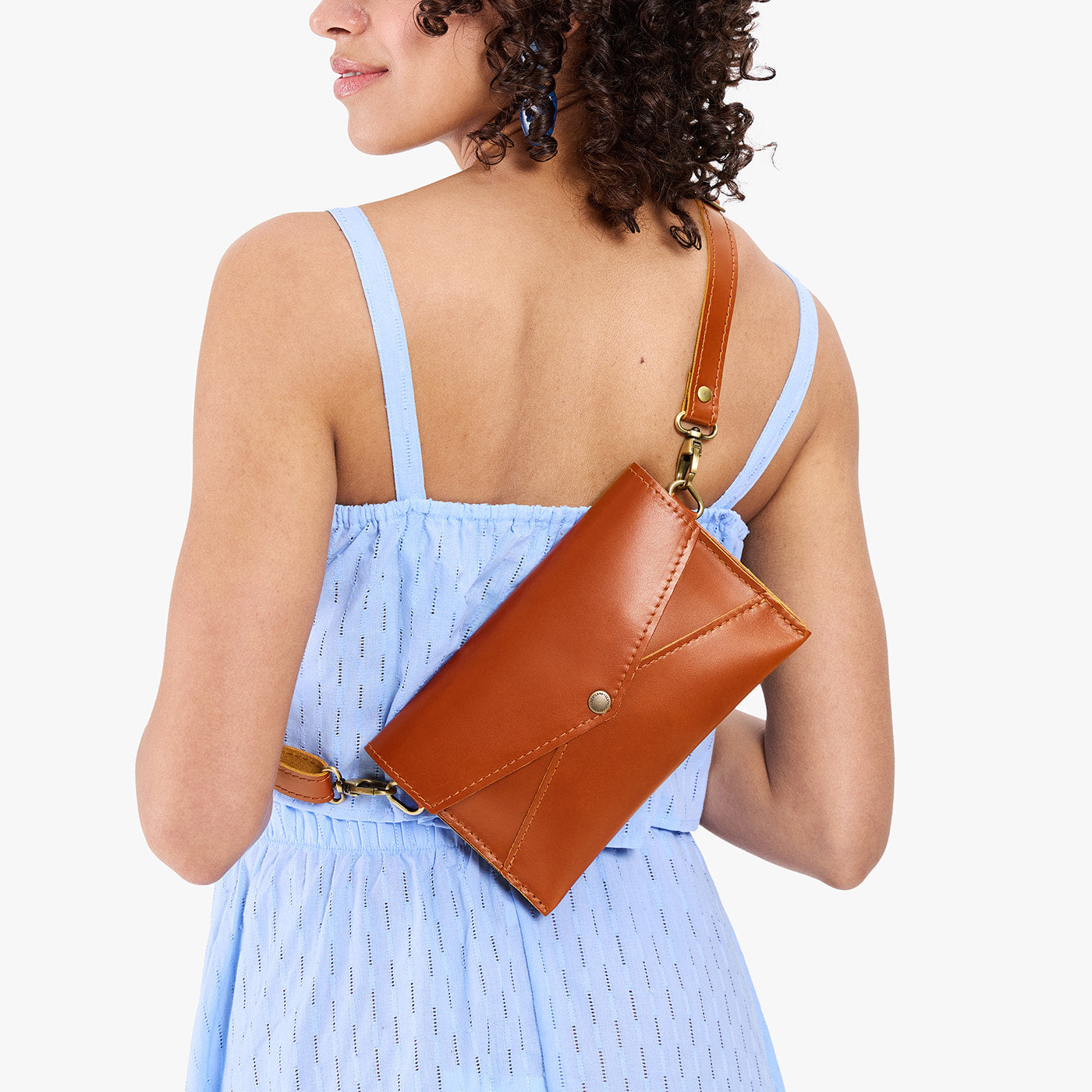 Madrone | Model holding envelope shaped clutch wallet with crossbody strap