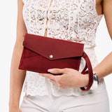 Phoenix | Model holding envelope shaped clutch wallet with crossbody strap