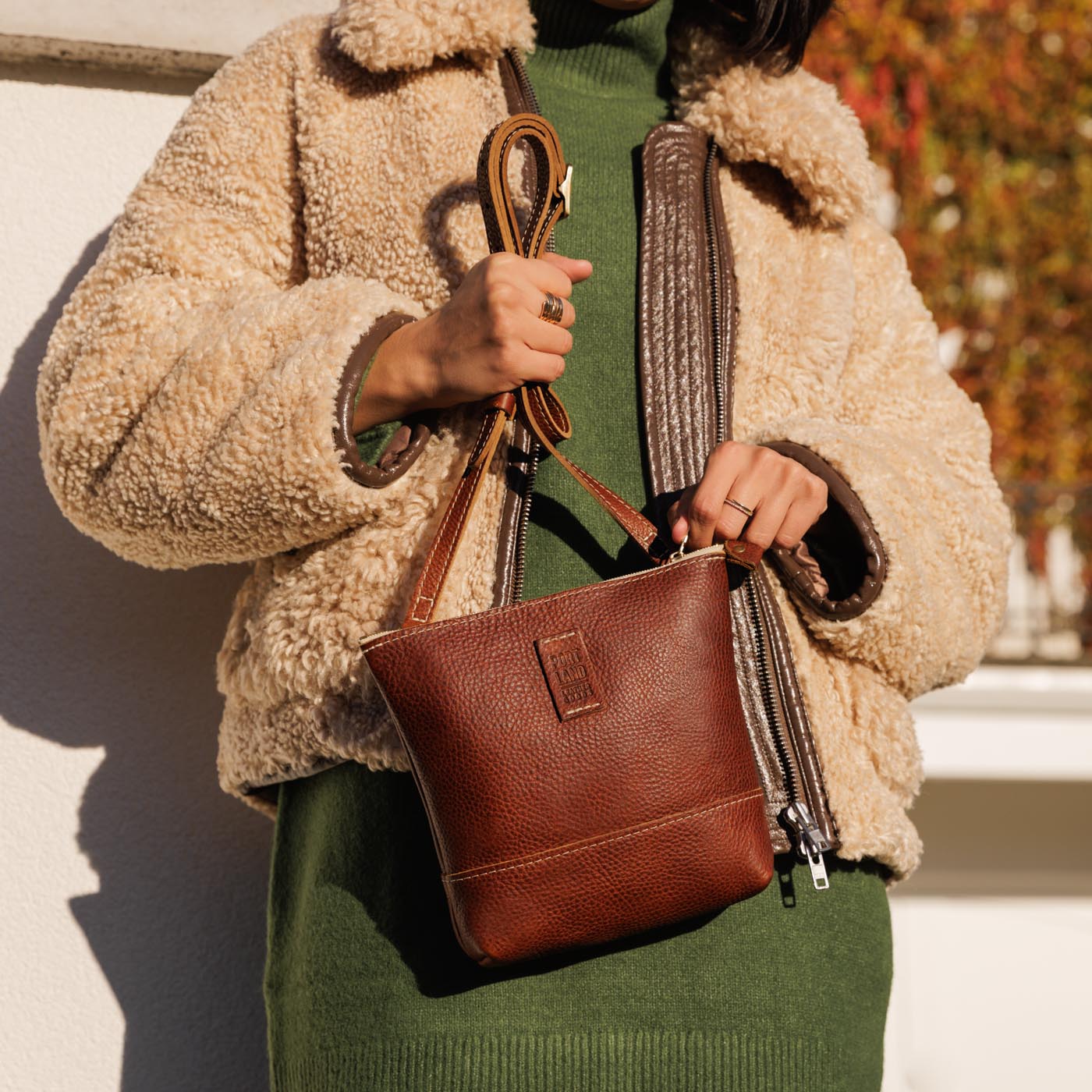 Nutmeg | Model holding small rectangular crossbody purse with top zipper and interior pocket