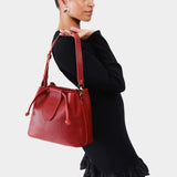 Chili Red Large | Model holding symmetrical leather bag with leather drawstring closure and adjustable shoulder strap