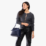 Cobalt Large | Model holding symmetrical leather bag with leather drawstring closure and adjustable shoulder strap