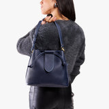 Cobalt Large | Model holding symmetrical leather bag with leather drawstring closure and adjustable shoulder strap