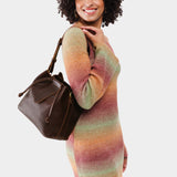 Coldbrew Large | Model holding symmetrical leather bag with leather drawstring closure and adjustable shoulder strap