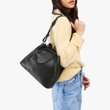 Pebbled--black Large | Model wearing symmetrical leather bag with leather drawstring closure and adjustable shoulder strap